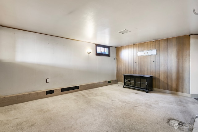 basement featuring carpet floors and wood walls