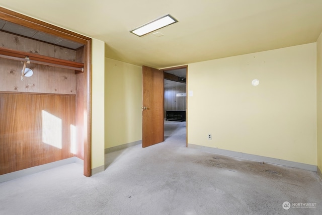 interior space with wooden walls and light colored carpet