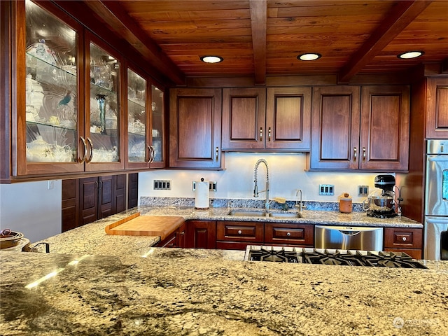 kitchen featuring sink, beam ceiling, appliances with stainless steel finishes, light stone countertops, and wooden ceiling