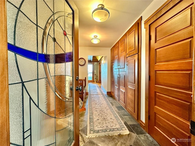 hallway with baseboards and stone finish flooring