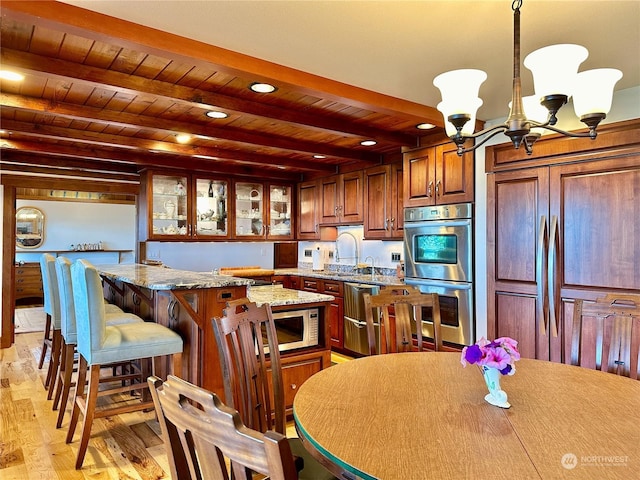 kitchen with beamed ceiling, a kitchen breakfast bar, wood ceiling, appliances with stainless steel finishes, and a notable chandelier