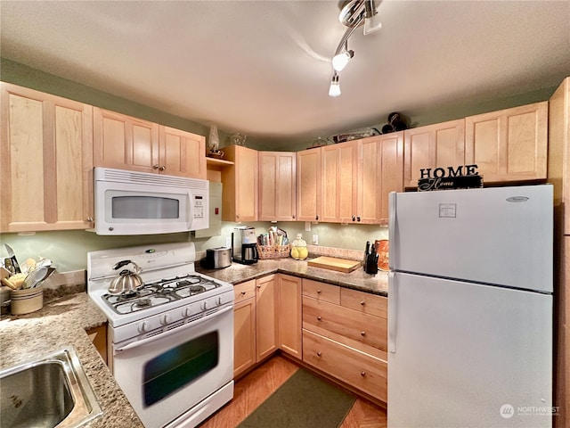 kitchen with sink, rail lighting, light hardwood / wood-style flooring, white appliances, and light brown cabinetry