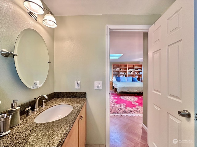 ensuite bathroom with connected bathroom and vanity