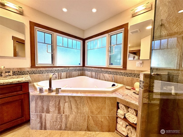 full bath featuring a tile shower, recessed lighting, vanity, and a garden tub