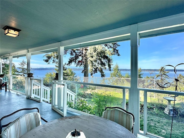 sunroom / solarium featuring a water view
