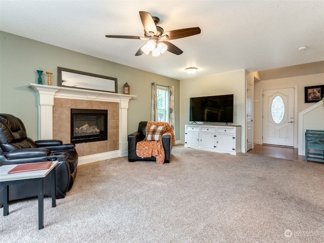 carpeted living room with a fireplace, ceiling fan, and plenty of natural light