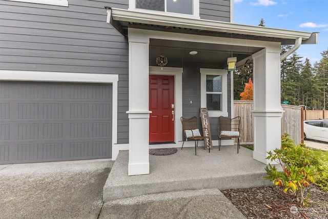 doorway to property featuring covered porch and a garage