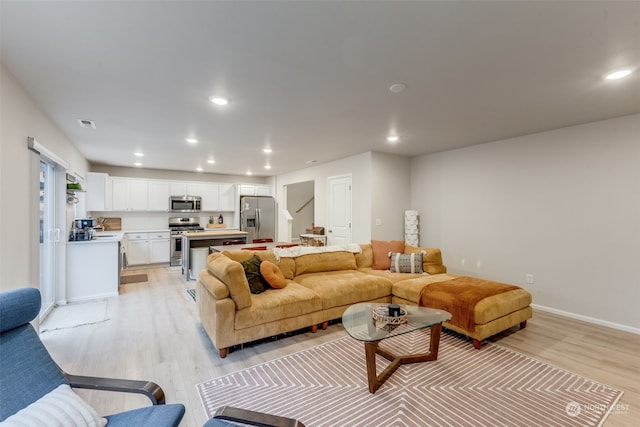 living room featuring light wood-type flooring and sink