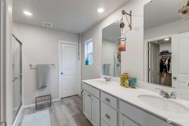 bathroom featuring wood-type flooring, vanity, and an enclosed shower