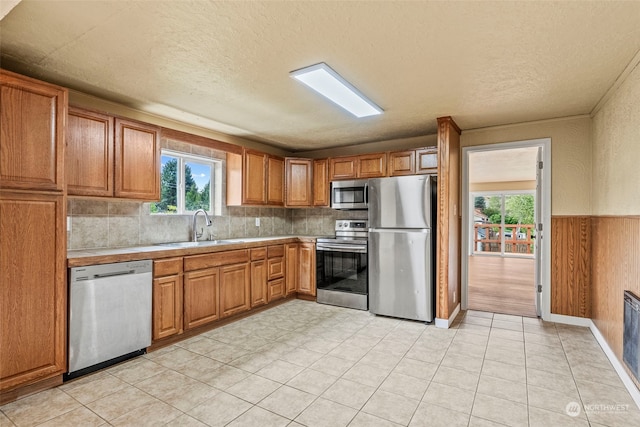 kitchen featuring light tile patterned floors, a textured ceiling, appliances with stainless steel finishes, and sink