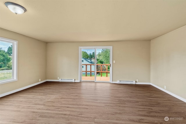 spare room featuring a baseboard radiator, light hardwood / wood-style floors, and plenty of natural light