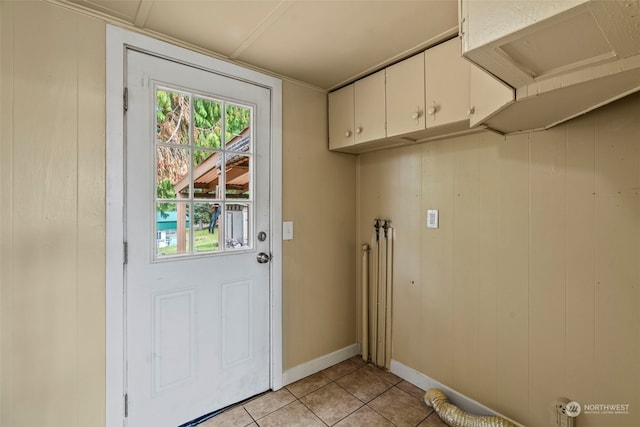 entryway with wood walls and light tile patterned floors