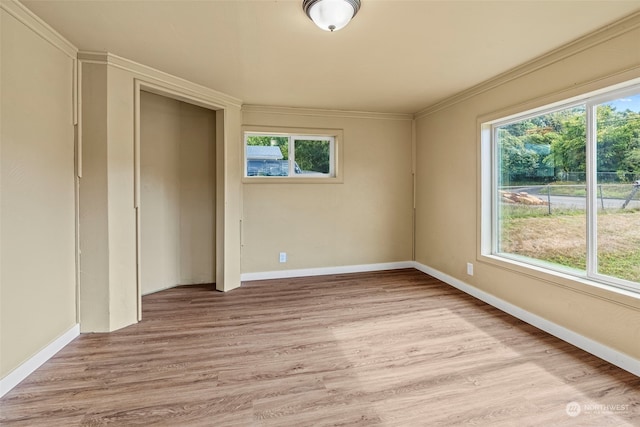 unfurnished bedroom featuring crown molding and light hardwood / wood-style flooring