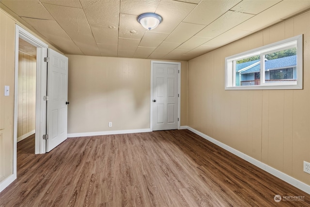 spare room with wood-type flooring and wooden walls