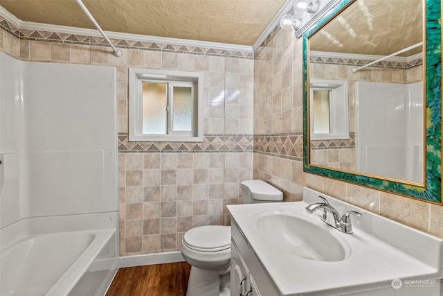 full bathroom featuring vanity, toilet, tile walls, crown molding, and hardwood / wood-style floors