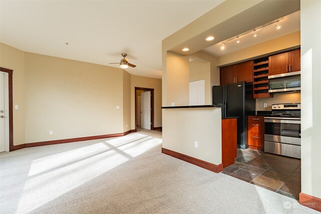 kitchen with appliances with stainless steel finishes, ceiling fan, and dark carpet