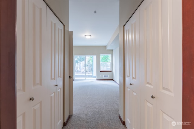 hall featuring light colored carpet