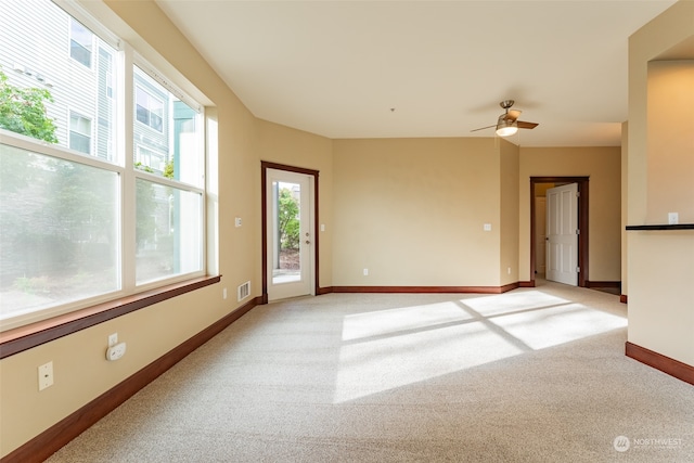 empty room with ceiling fan and light carpet