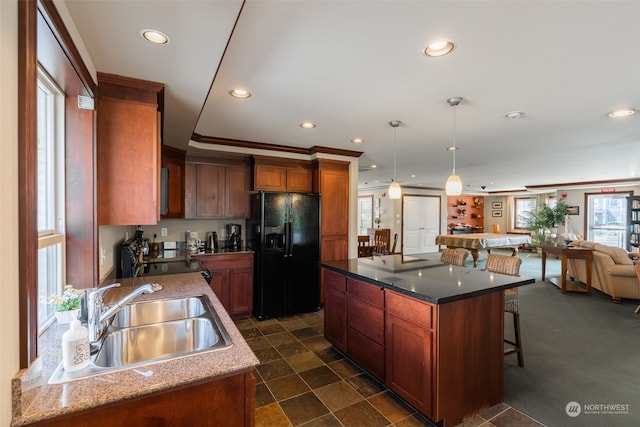 kitchen featuring sink, a kitchen island, decorative light fixtures, black appliances, and crown molding