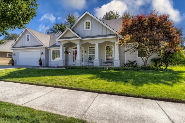 view of front facade with a porch, a garage, and a front yard