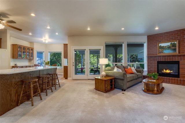 carpeted living room featuring ceiling fan, a fireplace, and bar