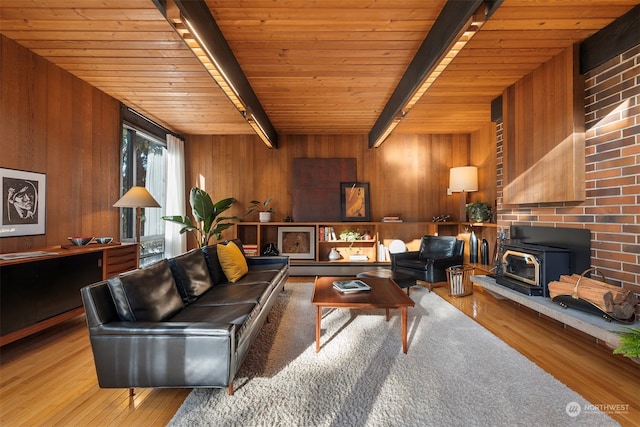 living room featuring wood ceiling, beamed ceiling, hardwood / wood-style flooring, a wood stove, and wood walls