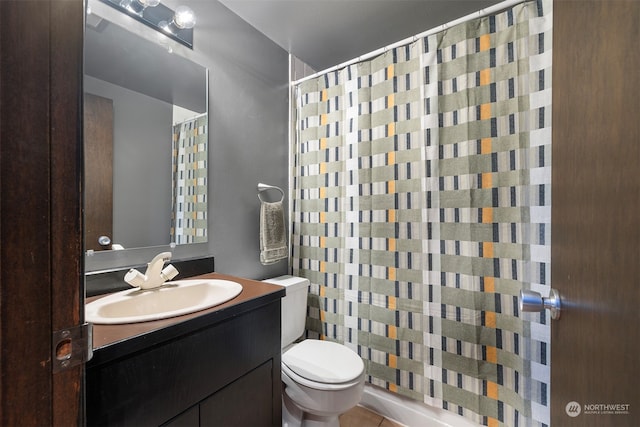 bathroom with tile patterned flooring, walk in shower, vanity, and toilet