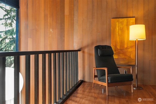 sitting room with wood walls and hardwood / wood-style floors