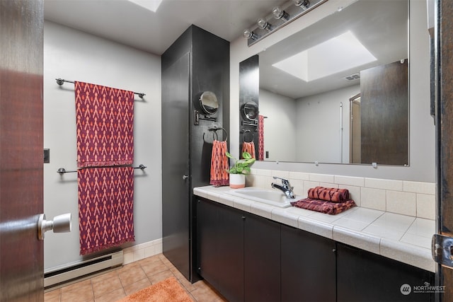 bathroom featuring a baseboard heating unit, tasteful backsplash, a skylight, tile patterned floors, and vanity