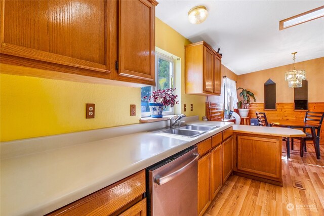 kitchen with light wood-type flooring, kitchen peninsula, hanging light fixtures, an inviting chandelier, and stainless steel dishwasher