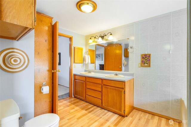 bathroom with vanity, hardwood / wood-style flooring, tile walls, and toilet