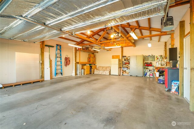 garage featuring a garage door opener and white refrigerator