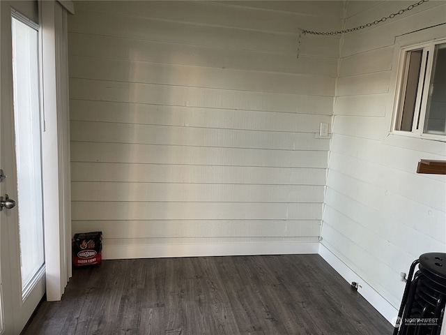 interior space with wood walls and dark hardwood / wood-style flooring