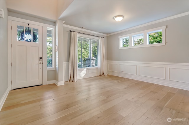 foyer entrance with light wood-type flooring and crown molding