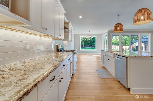 kitchen with pendant lighting, stainless steel appliances, white cabinetry, and light wood-type flooring