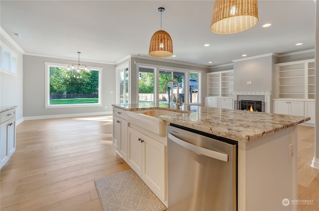 kitchen with light stone counters, sink, a kitchen island with sink, dishwasher, and light hardwood / wood-style floors