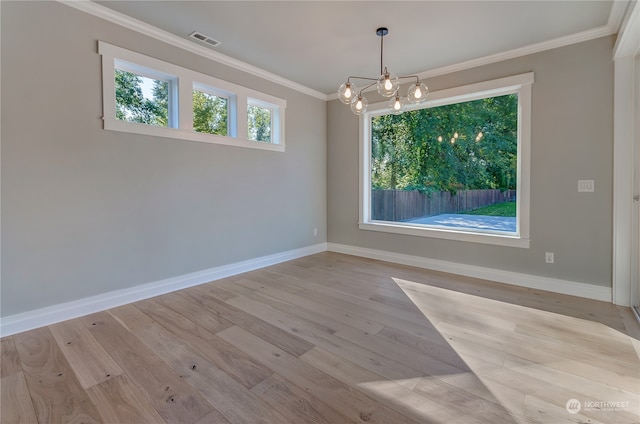 spare room featuring ornamental molding, light hardwood / wood-style flooring, and a chandelier