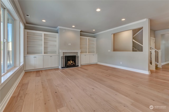 unfurnished living room featuring ornamental molding, light hardwood / wood-style floors, and a healthy amount of sunlight