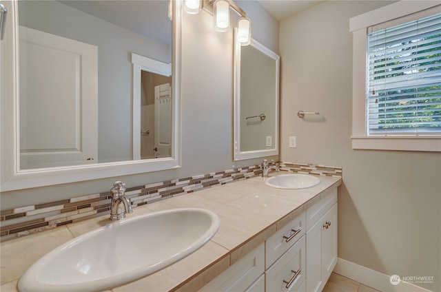 bathroom with tile patterned flooring, vanity, and backsplash