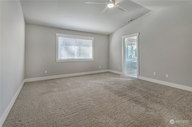 carpeted spare room featuring vaulted ceiling and ceiling fan