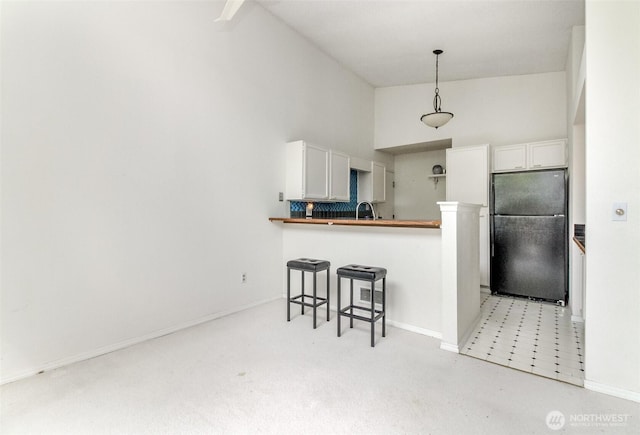 31717 48th Ln SW Unit A, Federal Way, WA 98023 - kitchen featuring freestanding refrigerator, a breakfast bar area, a sink, white cabinetry, and high vaulted ceiling