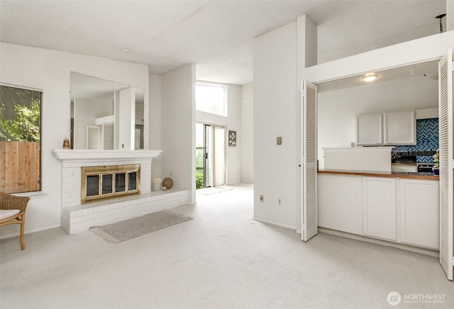 31717 48th Ln SW Unit A, Federal Way, WA 98023 - unfurnished living room featuring light colored carpet, a brick fireplace, baseboards, a heating unit, and a towering ceiling