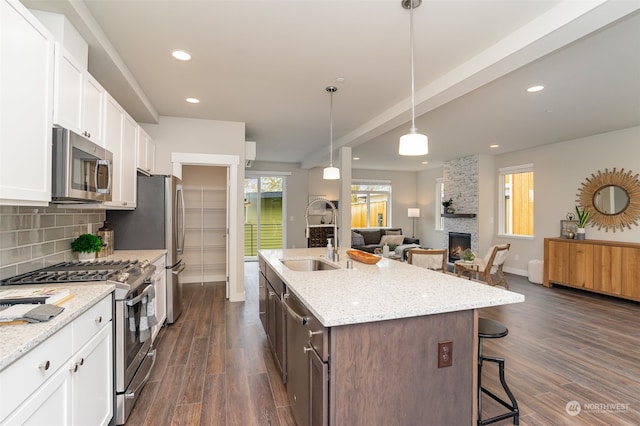 kitchen featuring appliances with stainless steel finishes, sink, dark wood-type flooring, and a kitchen breakfast bar