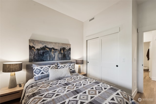 bedroom featuring a closet, hardwood / wood-style floors, and lofted ceiling