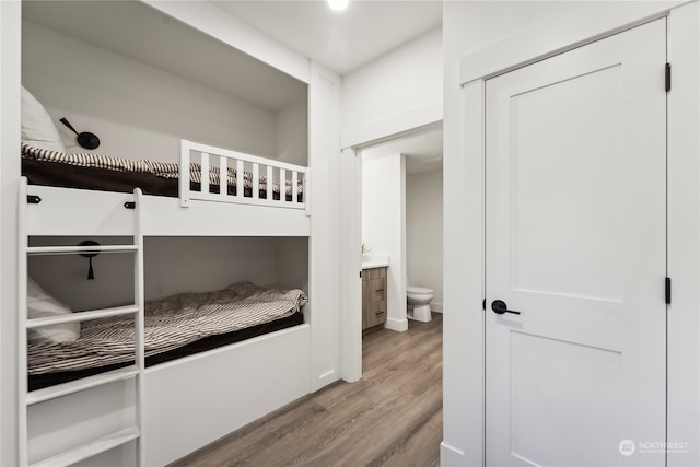 bedroom with light hardwood / wood-style flooring and ensuite bath