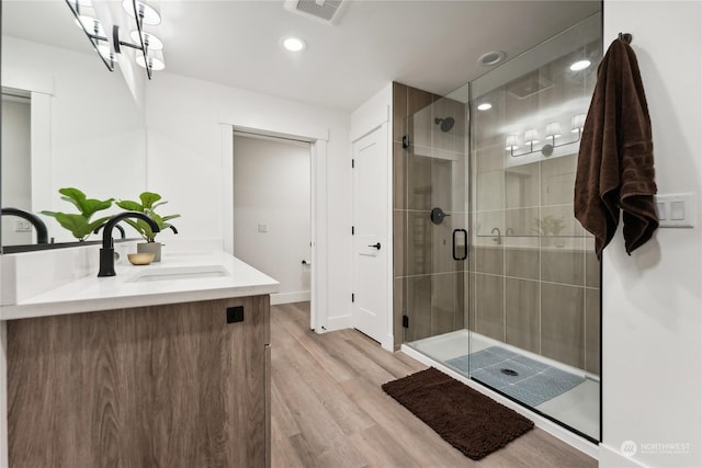 3760 Suncadia Trl Unit 313, Cle Elum, WA 98922 - bathroom with visible vents, a sink, a shower stall, double vanity, and wood finished floors