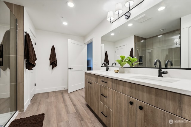 bathroom featuring a shower with door, hardwood / wood-style floors, and vanity