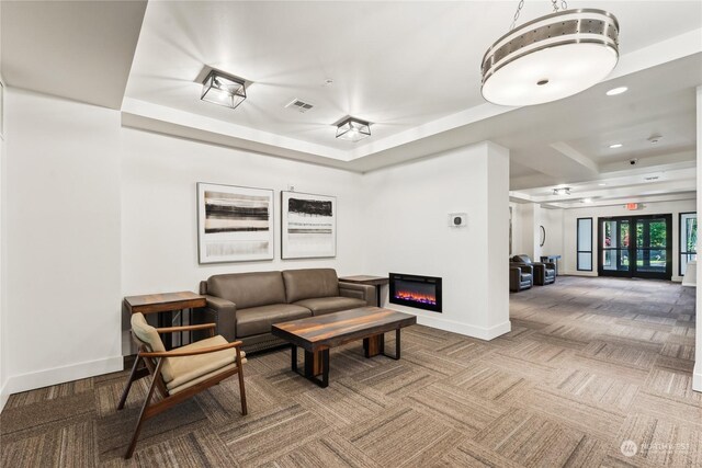 carpeted living room featuring a tray ceiling