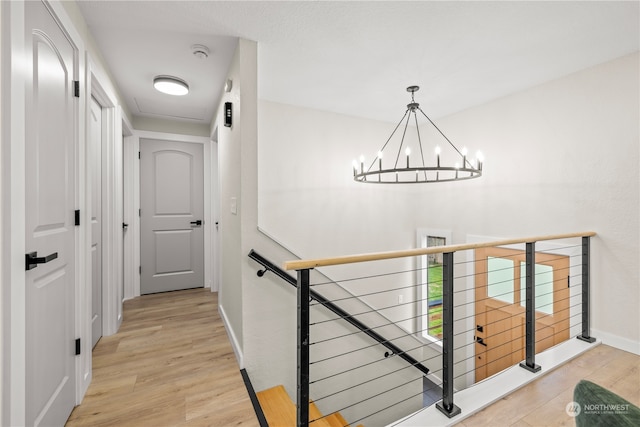 hallway featuring a notable chandelier and light hardwood / wood-style floors