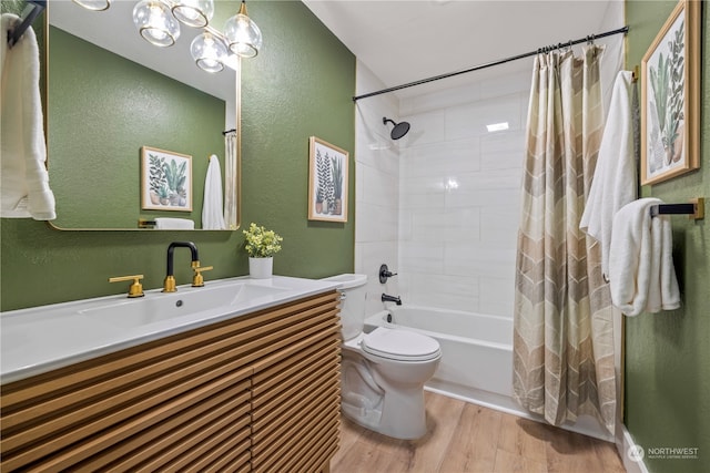 full bathroom with wood-type flooring, a chandelier, shower / tub combo with curtain, vanity, and toilet